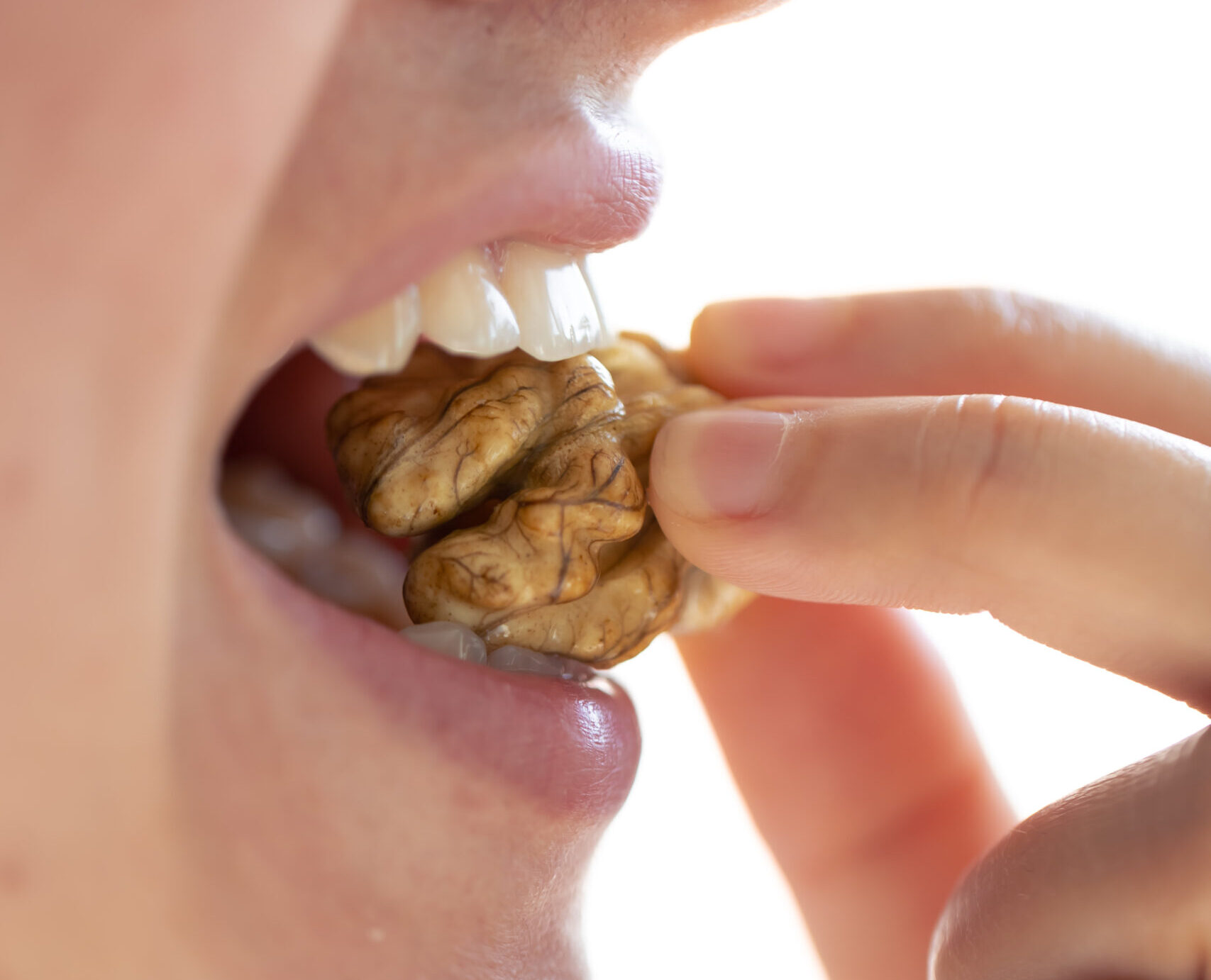 A girl biting a walnut showcasing biting issues